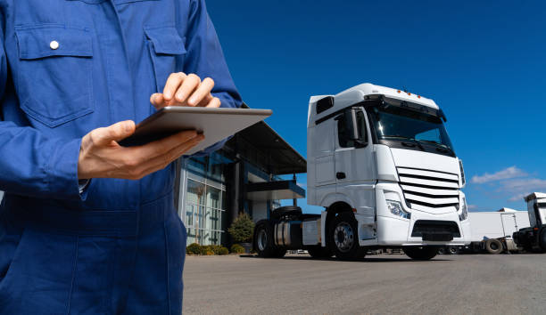Manager with a digital tablet next to trucks. Fleet management. Manager with a digital tablet next to trucks. Fleet management.